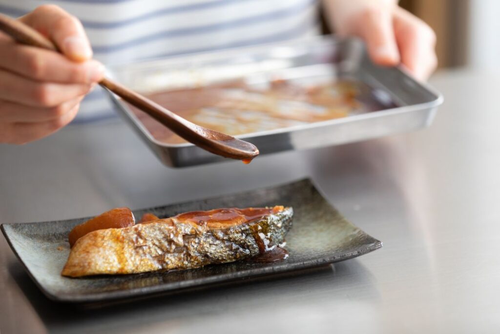 煮汁をスプーンでかける